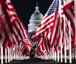 epa08947560 A person walks through the public art display 'Field of Flags', made up of over 200,000 flags intended to represent the American people who are unable to attend the upcoming presidential inauguration, across the National Mall in front of the US Capitol in Washington, DC, USA, 18 January 2021. Joe Biden will be sworn-in as the 46th US President on 20 January.  EPA/JUSTIN LANE