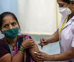 epa08947964 A beneficiary gets their first dose of a Covid-19 vaccine shot, manufactured by Serum Institute of India, inside Vaccination Centre at Rajawadi Hospital in Mumbai, India, 19 January 2021. One of the world's biggest and nationwide COVID-19 vaccination drive launched by Indian prime minister Narendra Modi and aimed at inoculating 30 million people in first drive that include front line workers like Accredited Social Health Activist (ASHA) doctors, MBBS students and nurses.  EPA/DIVYAKANT SOLANKI
