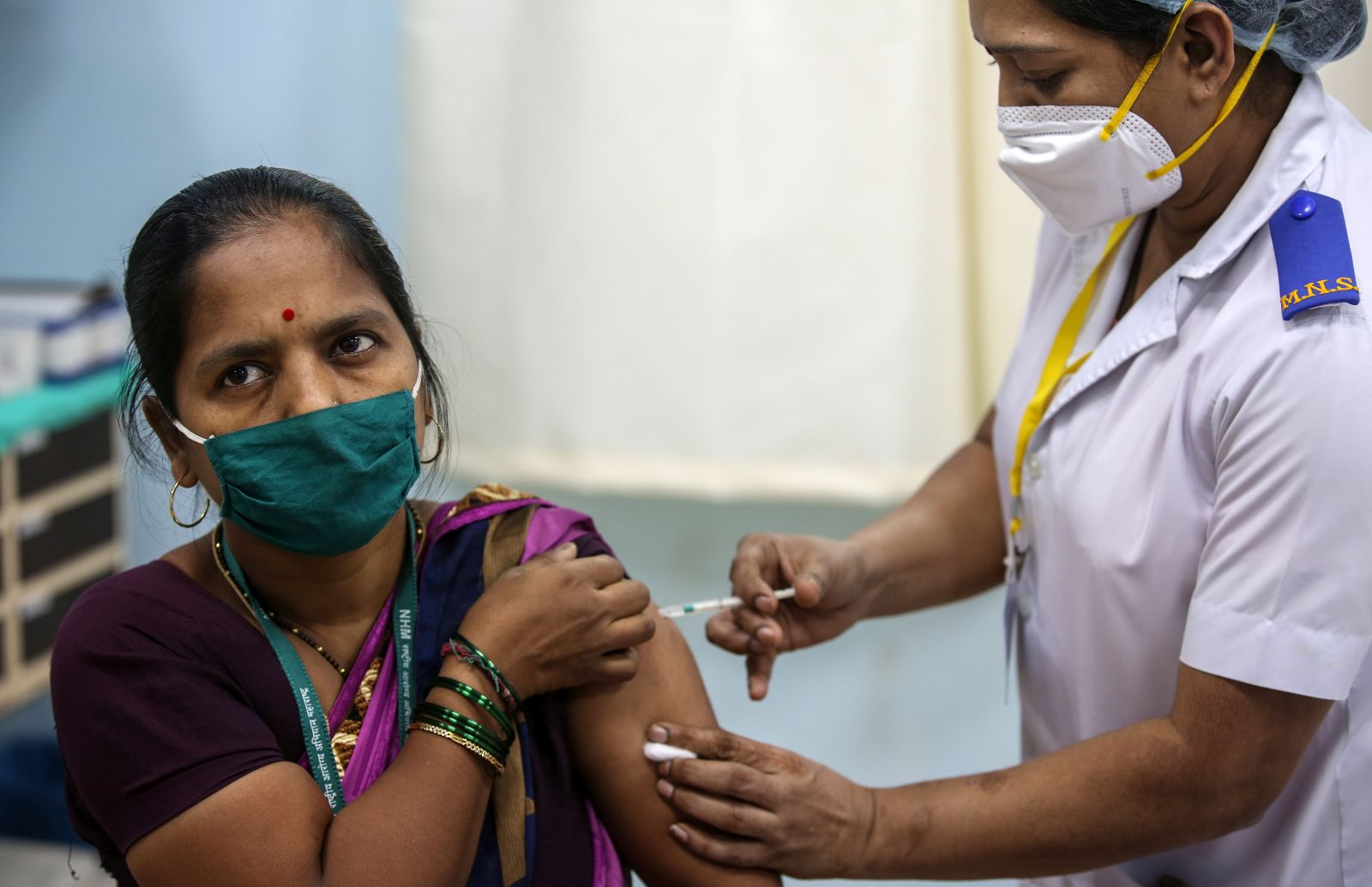 epa08947964 A beneficiary gets their first dose of a Covid-19 vaccine shot, manufactured by Serum Institute of India, inside Vaccination Centre at Rajawadi Hospital in Mumbai, India, 19 January 2021. One of the world's biggest and nationwide COVID-19 vaccination drive launched by Indian prime minister Narendra Modi and aimed at inoculating 30 million people in first drive that include front line workers like Accredited Social Health Activist (ASHA) doctors, MBBS students and nurses.  EPA/DIVYAKANT SOLANKI