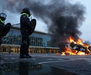 epa08963211 A car has been set on fire in front of the station on the 18 Septemberplein in Eindhoven, the Netherlands, 24 January 2021. Far-right anti-Islam movement Pegida had announced a protest which was banned by the Eindhoven Mayor Jorritsma for fear of disturbances.  EPA/ROB ENGELAAR