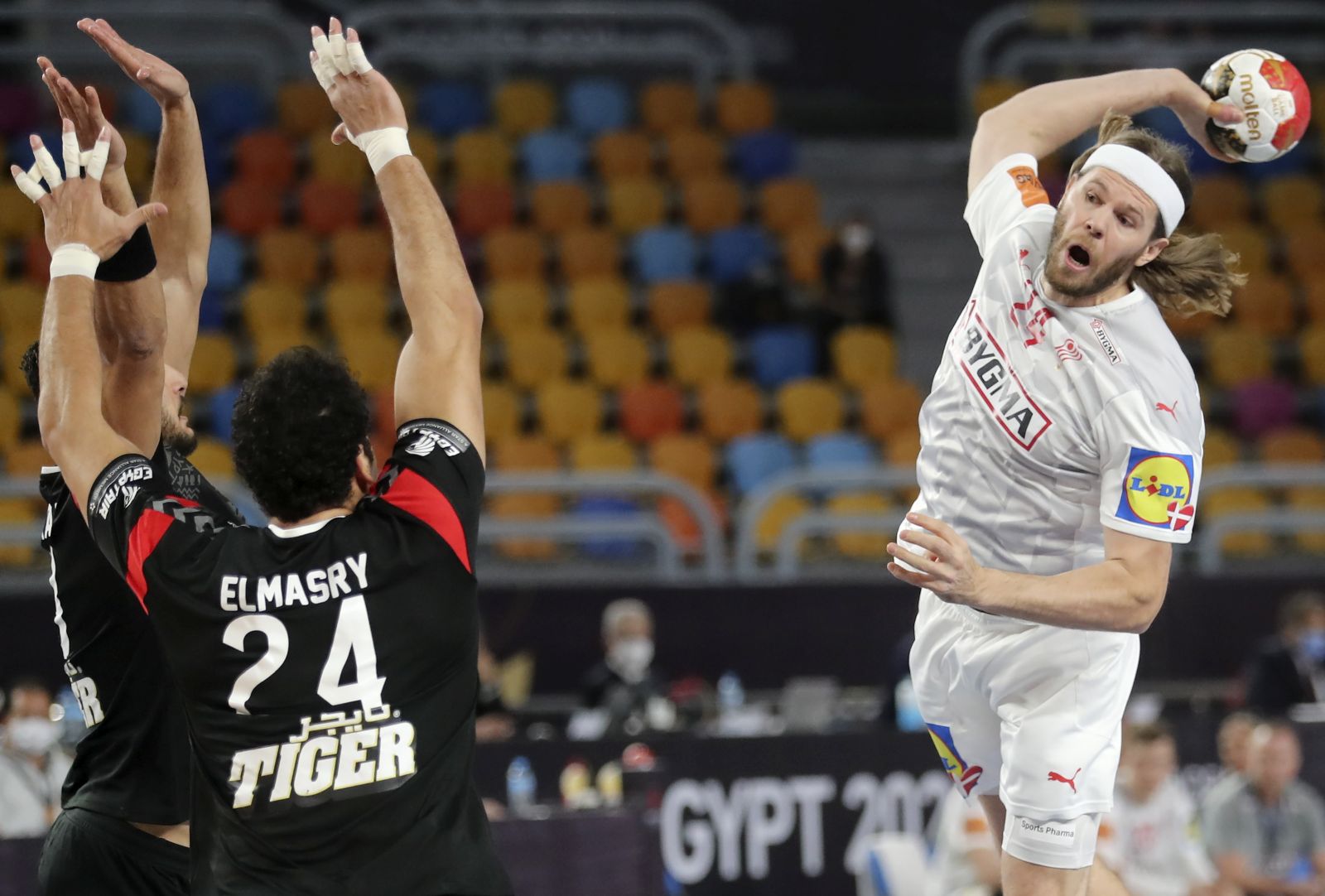 epa08969025 Denmark's Mikkel Hansen (R) in action against Egypt’s Ibrahim Elmasry (L) during the quarter final match between Denmark and Egypt at the 27th Men's Handball World Championship in Cairo, Egypt, 27 January 2021.  EPA/Mohamed Abd El Ghany / POOL