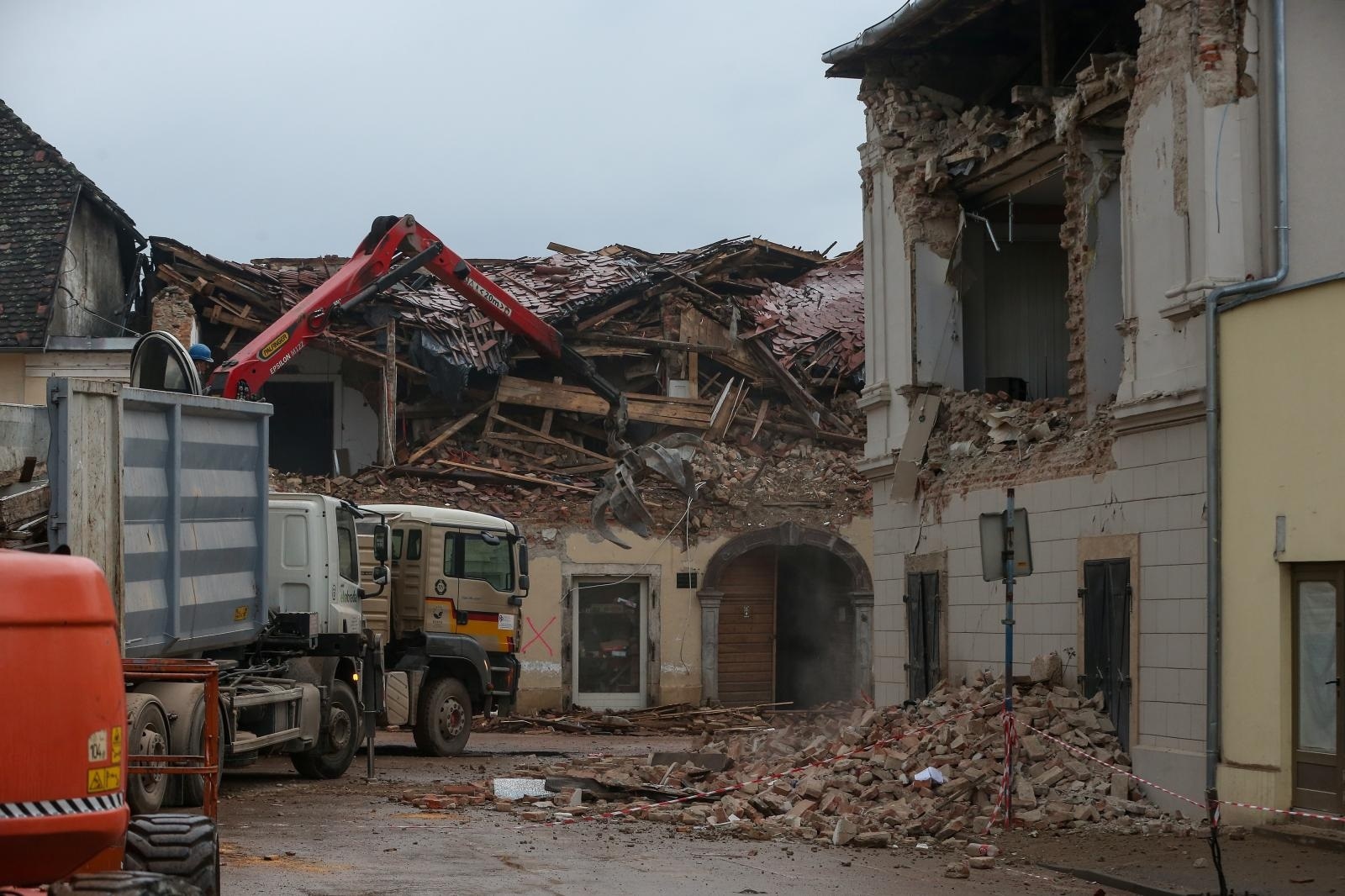 02.12.2021., Petrinja - Peti dan nakon razornog potresa saniraju se posljedice. Radnici sa strojevima ruse kuce u centru, a vatrogasci skidaju dimljake i pokrivaju krovove s najlonima dok ljudi spasavaju iz rusevina ono malo stvari sto potres nije unistio.  Photo: Zeljko Lukunic/PIXSELL