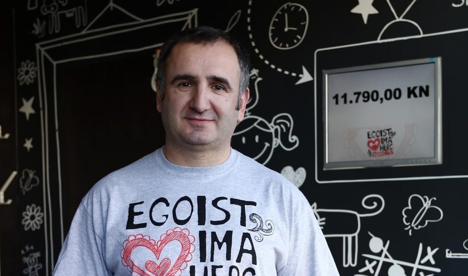 13.02.2014., Zagreb -  Vlasnik i djelatnici Caffe bara Egoist na jarunskoj trznici pokrenuli su humanitarnu akciju za siromasnu obitelj iz susjedstva u kojoj je do sada prodajom majica i bedzeva skupljeno 11790 kuna. Vlasnik kafica Drazen Biljan. 
Photo: Davor Puklavec/PIXSELL