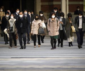 epa08972211 Commuters cross a street at Otemachi business district in Tokyo, Japan, 29 January 2021. According to data released by the Japanese government, the country’s availability ratio marked a decrease of 0.42 points from the previous year to 1.18, its largest decline since 1975, due to the coronavirus pandemic. The annual jobless rate increased slightly to 2.8 percent in 2020.  EPA/FRANCK ROBICHON