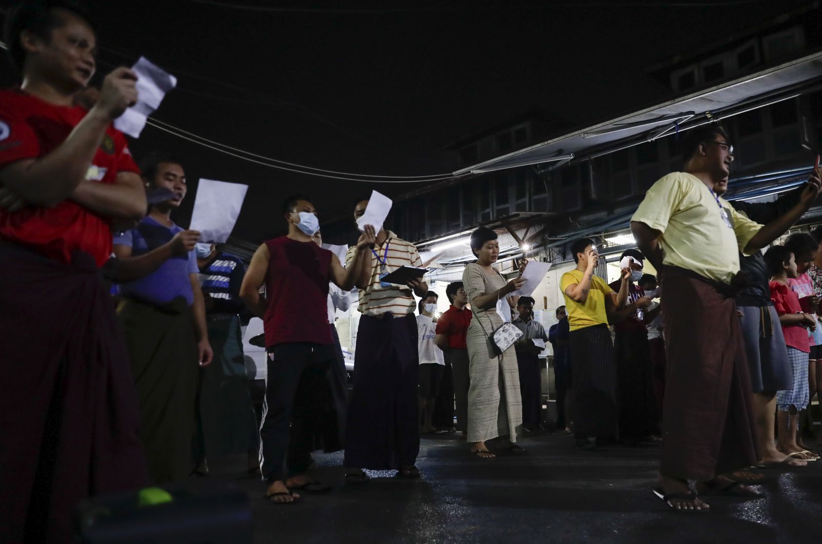 epa08989279 Myanmar people sing resistance songs at a street as a symbol of resistance against the military coup at the downtown area in Yangon, Myanmar, 05 February 2021. People in Yangon hit pots and pans together producing noise (that sound is believed to drive the evils away in Burmese tradition) at 8:00 PM local time as a symbol of resistance to the recent military coup. Myanmar's Aung San Suu Kyi and other top political leaders were detained in a military coup on 01 February amid allegations of voter fraud in the November 2020 elections.  EPA/LYNN BO BO