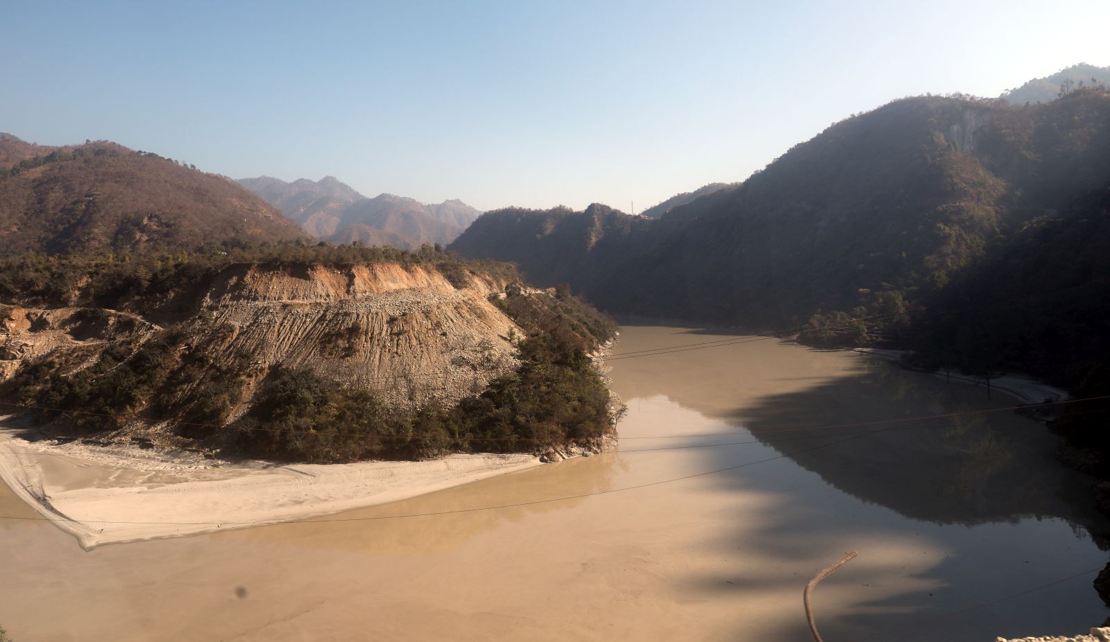 epa08995388 View of the overflowed Mandakini river, a tributary of the Alaknanda River, near the Rudraprayag district in Uttarakhand, India, 08 February 2021. At least 11 people died and nearly 150 are still missing after part of the Nanda Devi glacier fell into the river, triggering a flood that burst open a dam in the Tapovan area of Uttarakhand's Chamoli district on 07 February 2021.  EPA/RAJAT GUPTA