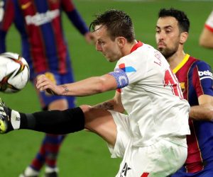 epa09002320 Sevilla's Ivan Rakitic (L) in action against FC Barcelona's Sergio Busquets (R) during the Spanish King's Cup semi final, first leg soccer match between Sevilla FC and FC Barcelona at Ramon Sanchez Pizjuan stadium in Seville, Spain, 10 February 2021.  EPA/Julio Munoz