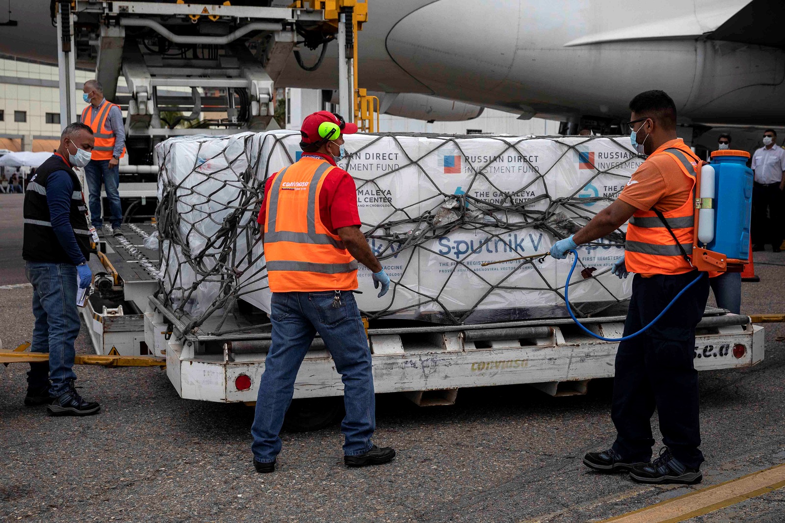 epa09010566 Airport personnel unload boxes with the Sputnik V vaccines at the Maiquetia International Airport, near Caracas, Venezuela, 13 February 2021. A first batch of the Russian Sputnik V vaccine against covid-19 arrived on 13 February at the Maiquetía International Airport, which serves Caracas, on a plane from Moscow of the Venezuelan state airline Conviasa, as part of the contract established between Venezuela and Russia for ten million doses.  EPA/RAYNER PEÑA R