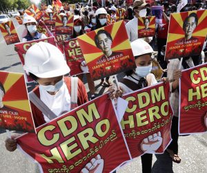epa09011099 Demonstrators hold placards calling for the release of detained State Counselor Aung San Suu Kyi and support for the Civil Disobedience Movement (CDM) during a protest against the military coup outside the Chinese embassy in Yangon, Myanmar, 14 February 2021. Protests continue across the country despite orders banning mass gatherings and reports of police arresting anti-coup protesters in night-time arrests. Myanmar’s military junta on 13 February ordered the arrest of several prominent anti-coup activists while suspending privacy laws that restricted police from detaining suspects or searching private property without court warrants.  EPA/LYNN BO BO