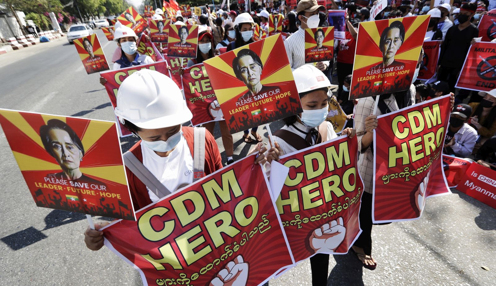 epa09011099 Demonstrators hold placards calling for the release of detained State Counselor Aung San Suu Kyi and support for the Civil Disobedience Movement (CDM) during a protest against the military coup outside the Chinese embassy in Yangon, Myanmar, 14 February 2021. Protests continue across the country despite orders banning mass gatherings and reports of police arresting anti-coup protesters in night-time arrests. Myanmar’s military junta on 13 February ordered the arrest of several prominent anti-coup activists while suspending privacy laws that restricted police from detaining suspects or searching private property without court warrants.  EPA/LYNN BO BO
