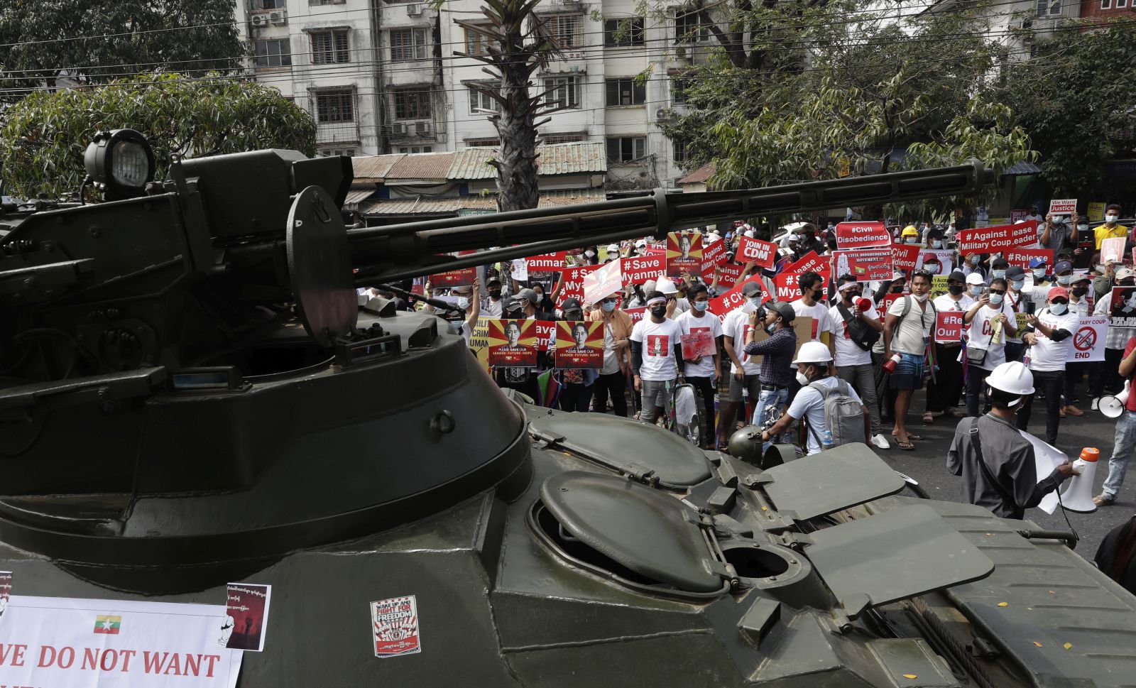 epa09014258 Demonstrators gather near a road where soldiers and armored vehicles are deployed during a protest outside the Central Bank of Myanmar (CBM) in Yangon, Myanmar, 15 February 2021. Myanmar's military junta on 15 February cut internet services and deployed troops and armoured vehicles across the country in signs of increasing force to clamp down on mass protests against the military coup and the growing civil disobedience movement that has crippled government services.  EPA/LYNN BO BO