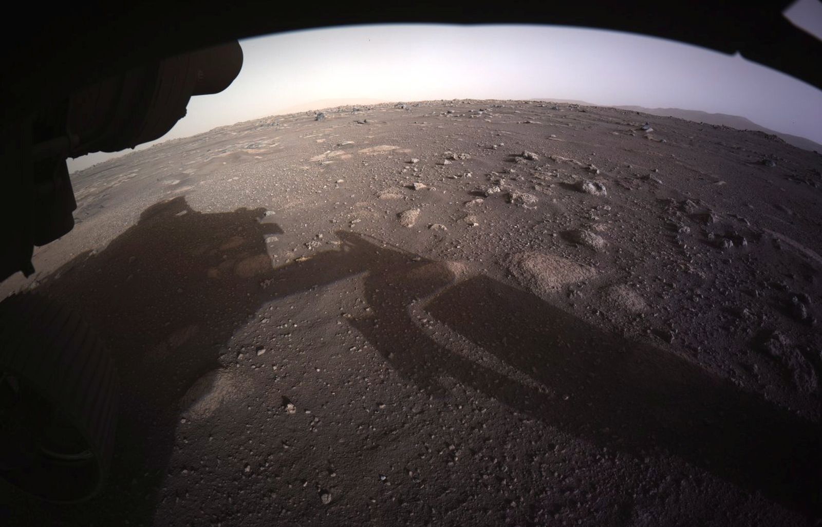 epa09024690 A handout photo made available by NASA shows the first high-resolution, color image to be sent back by the Hazard Cameras (Hazcams) on the underside of NASA's Perseverance Mars rover after its landing, on 18 February 2021 (issued 19 February 2021). A camera aboard the descent stage captured this shot. A key objective for Perseverance's mission on Mars is astrobiology, including the search for signs of ancient microbial life. The rover will characterize the planet's geology and past climate, pave the way for human exploration of the Red Planet, and be the first mission to collect and cache Martian rock and regolith.  EPA/NASA/JPL-Caltech HANDOUT  HANDOUT EDITORIAL USE ONLY/NO SALES