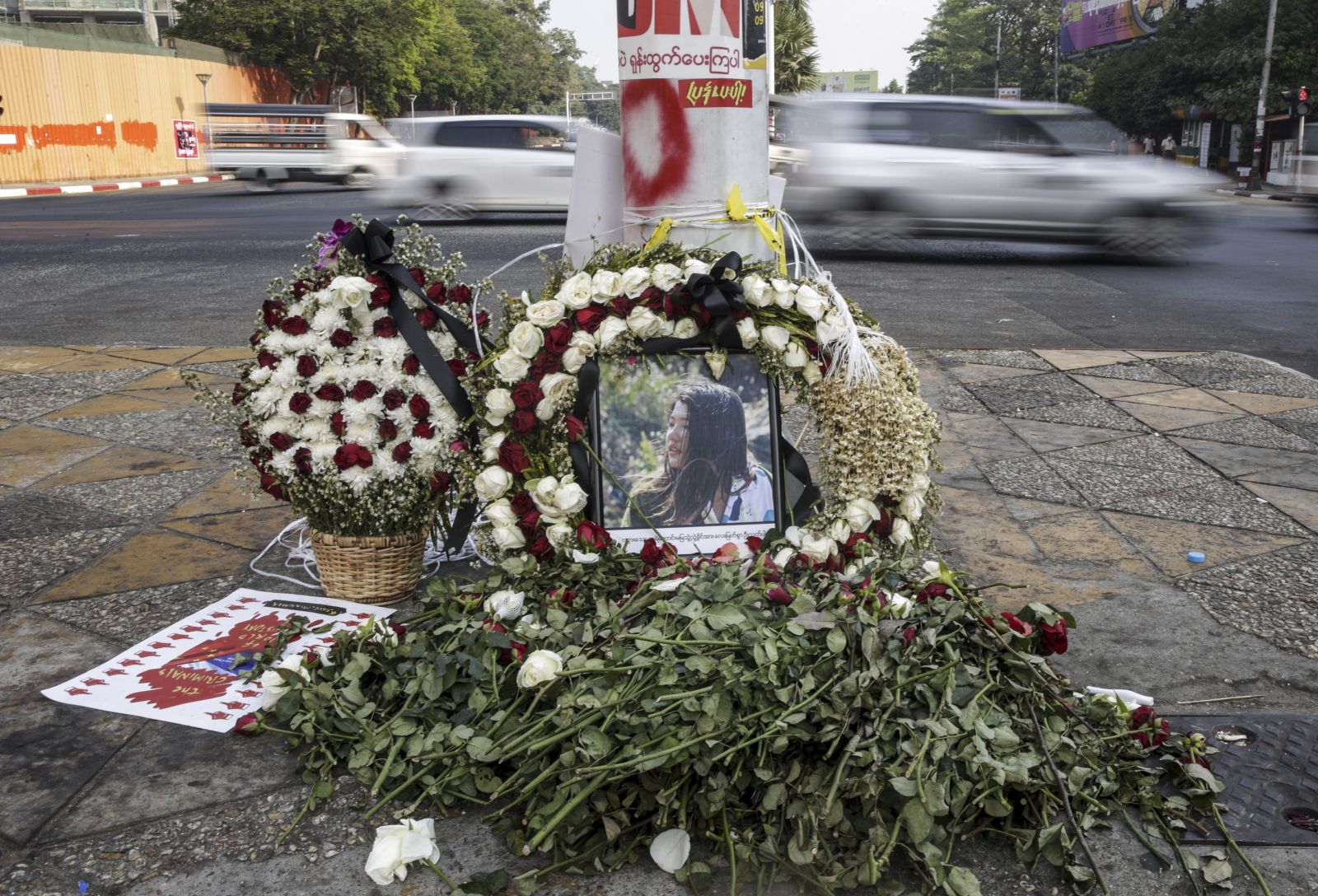 epa09027033 Flowers and a portrait photo of Mya Thwe Thwe Khaing are laid down in the street during a protest in Yangon, Myanmar, 21 February 2021. Mya Thwe Thwe Khaing, 20, passed away on 19 February after being on life support since being admitted to hospital on 09 February, following a severe head injury, allegedly from a live bullet shot in the head in an anti-coup protest in Naypyitaw. Another two people were killed and several people injured after police fired live rounds to disperse protesters in Myanmar's second-largest city Mandalay on 20 February.  EPA/LYNN BO BO