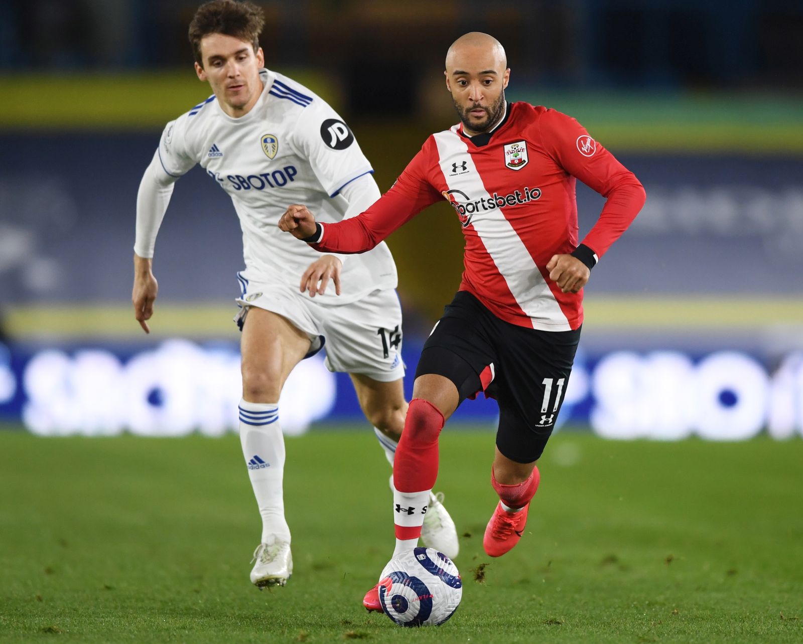 epa09032122 Diego Llorente of Leeds (L) in action against Nathan Redmond of Southampton (R) during the English Premier League soccer match between Leeds United and Southampton FC in Leeds, Britain, 23 February 2021.  EPA/Gareth Copley / POOL EDITORIAL USE ONLY. No use with unauthorized audio, video, data, fixture lists, club/league logos or 'live' services. Online in-match use limited to 120 images, no video emulation. No use in betting, games or single club/league/player publications.