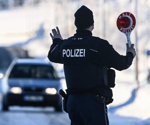 epa09011283 A member of the German Federal Police stops a car at the border crossing in Zinnwald, on the Germany-Czech Republic border, 14 February 2021. Germany reinstated temporary entry bans and border controls from Czech Republic due to growing numbers of coronavirus variant cases in the Czech country. Starting from 14 February, stricter entry rules apply to the German border with the Czech Republic and the Austrian state of Tyrol.  EPA/FILIP SINGER