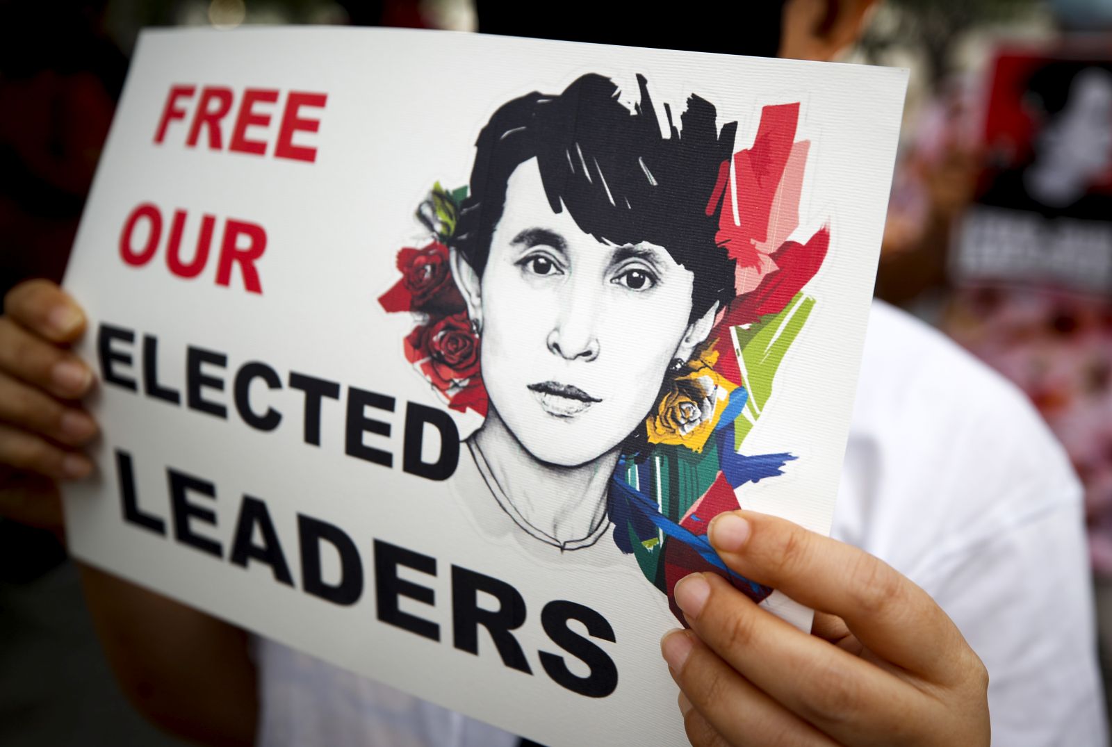 epa09018531 A Myanmar demonstrator wearing a protective face mask holds a sign with the image of Myanmar democracy icon Aung San Suu Kyi during a protest against the Myanmar military coup, outside the United Nations building in Bangkok, Thailand, 17 February 2021. Myanmar nationals living in Thailand continue to rally against the military coup, and in support of their democratic leader Aung San Suu Kyi and other top political leaders who were detained in a raid during a military coup, after tensions rose between the civilian government and the military, who disputed the legitimacy of the November 2020 elections results.  EPA/DIEGO AZUBEL