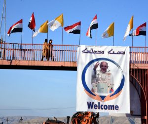 epa09044220 A view shows Iraqi and Vatican flags and the picture of Pope Francis at the Assyrian town of Qaraqosh, some 13 km east of Mosul, northern Iraq, 25 February 2021 (issued 01 March 2021). Pope Francis will visit the Church of Grand Immaculate near Mosul, during his trip to Iraq from 05 to 08 March 2021.  EPA/AMMAR SALIH