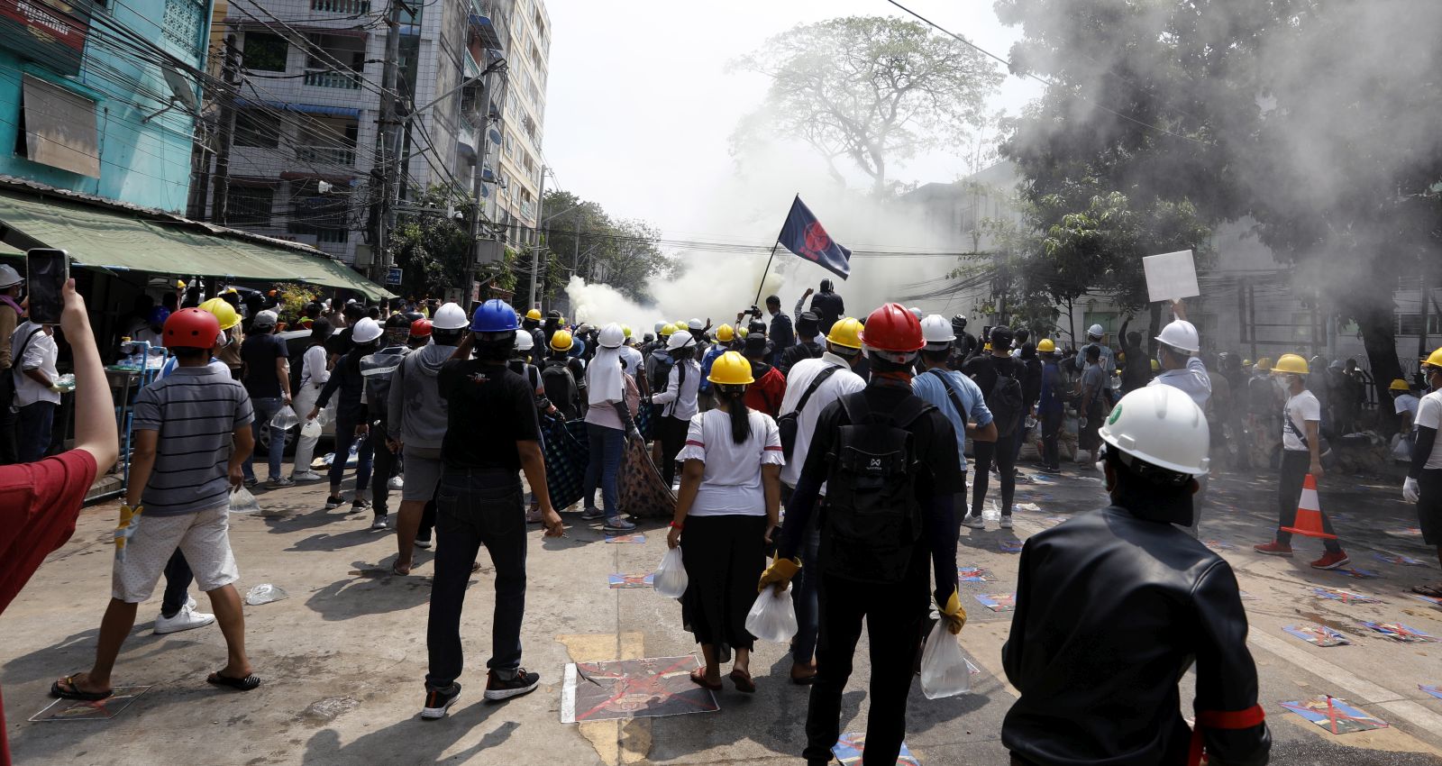 epa09047910 Protesters flee from tear gas launched by police during a protest against the military coup in Yangon, Myanmar, 03 March 2021. Foreign ministers of the Association of Southeast Asian Nations (ASEAN) call for a halt of violence during a meeting on 02 March as protests continued amid rising tension in the country between anti-coup protesters and security forces.  EPA/NYEIN CHAN NAING
