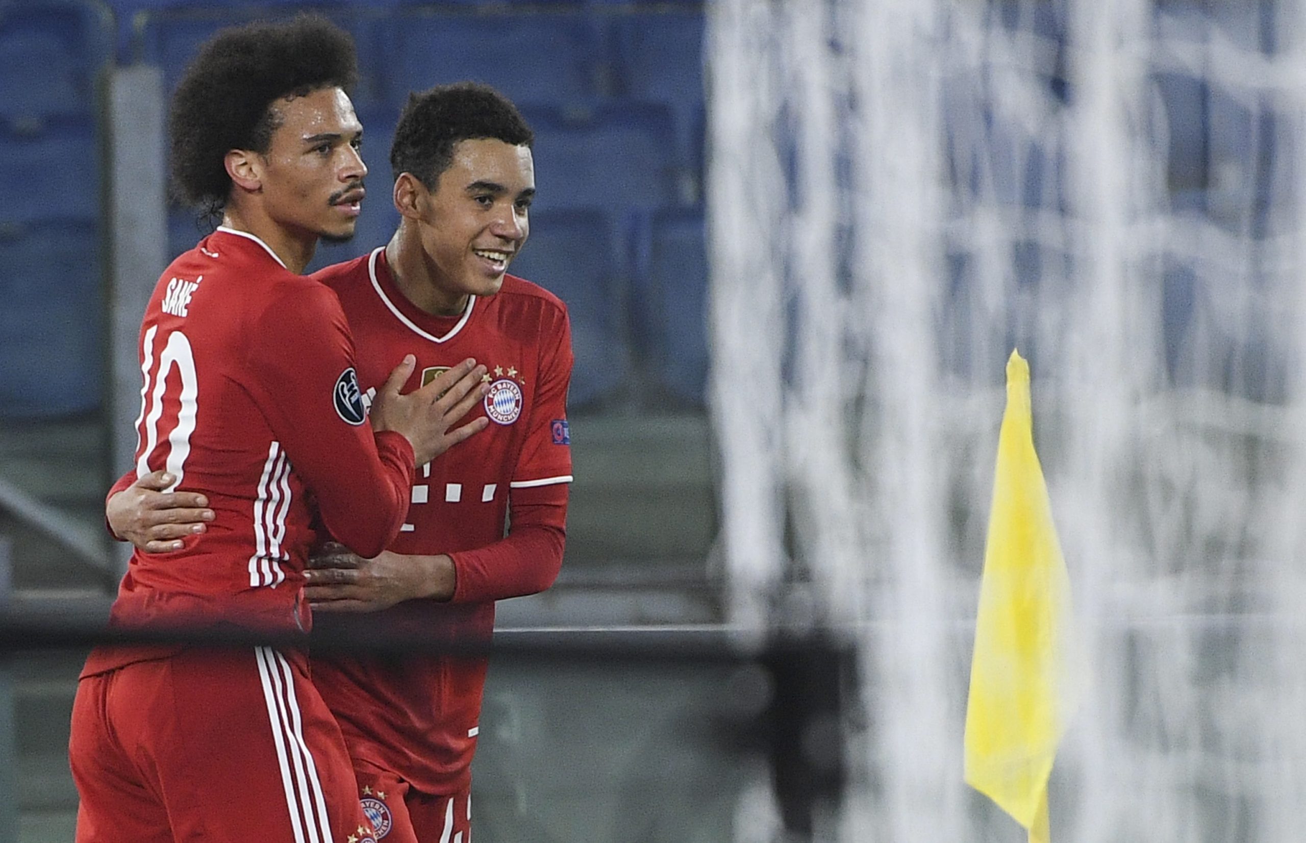 epa09032655 Bayern’s Jamal Musiala (R) celebrates with  teammate Leroy Sane (L) after scoring the 0-2 goal during UEFA Champions League round of 16 first leg soccer match between SS Lazio and Bayern Munich at Stadio Olimpico in Rome, Italy, 23 February 2021.  EPA/MAURIZIO BRAMBATTI