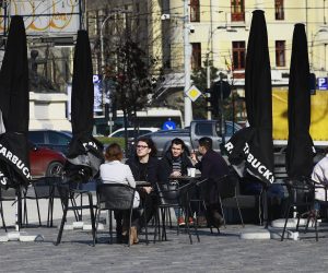 epa09054347 Young Romanian people enjoy a sunny day and their drinks at a terrace at University Plaza, in Bucharest, Romania, 05 March 2021. As the COVID-19 infections number increased recently, Romania's capital is close to the red scenario, in which schools, cinemas and restaurants shall be closed.  EPA/ROBERT GHEMENT