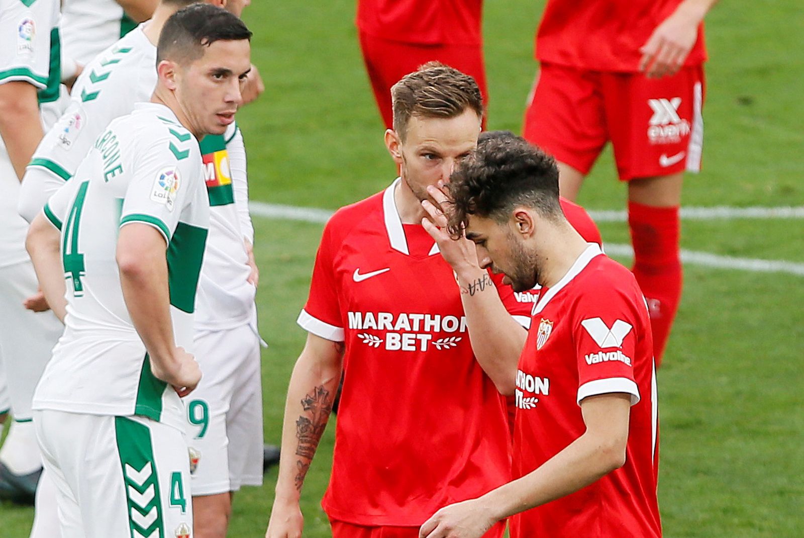 epa09057005 Sevilla's Spanish-Moroccan winger Munir El Haddadi (R) talks with Croatian midfielder Ivan Rakitic (C) during their LaLiga soccer match played Martinez Valero Stadium, in Elche, Spain, 03 March 2021.  EPA/Manuel Lorenzo