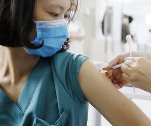 epa09063116 A medical worker receives a sot of COVID-19 vaccine at Thanh Nhan hospital in Hanoi, Vietnam, 09 March 2021.  Vietnam launched its COVID-19 vaccination campaign on 08 March, after receiving the first batch of AstraZeneca vaccine which were manufactured in South Korea and imported by Vietnam Vaccine Company (VNVC) in February.  EPA/LUONG THAI LINH