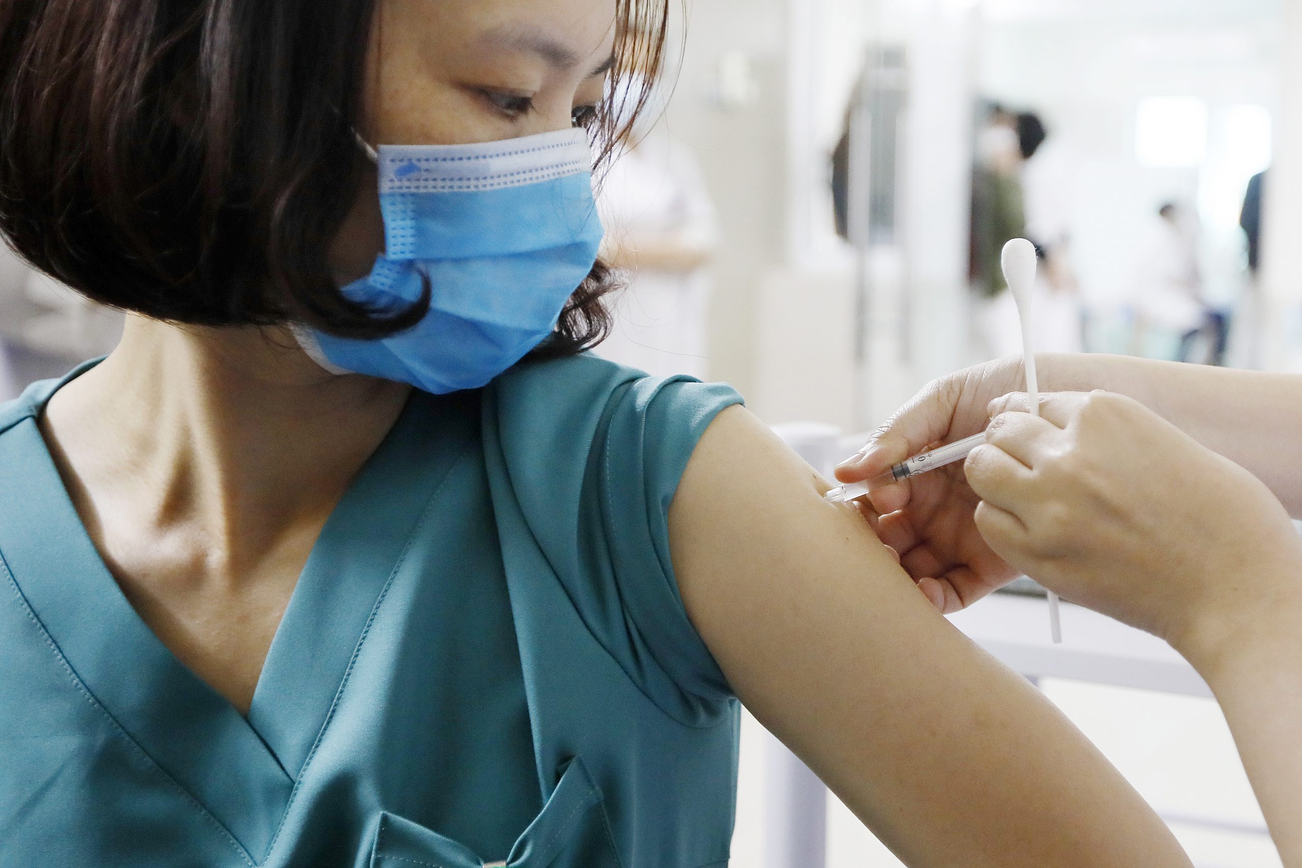 epa09063116 A medical worker receives a sot of COVID-19 vaccine at Thanh Nhan hospital in Hanoi, Vietnam, 09 March 2021.  Vietnam launched its COVID-19 vaccination campaign on 08 March, after receiving the first batch of AstraZeneca vaccine which were manufactured in South Korea and imported by Vietnam Vaccine Company (VNVC) in February.  EPA/LUONG THAI LINH