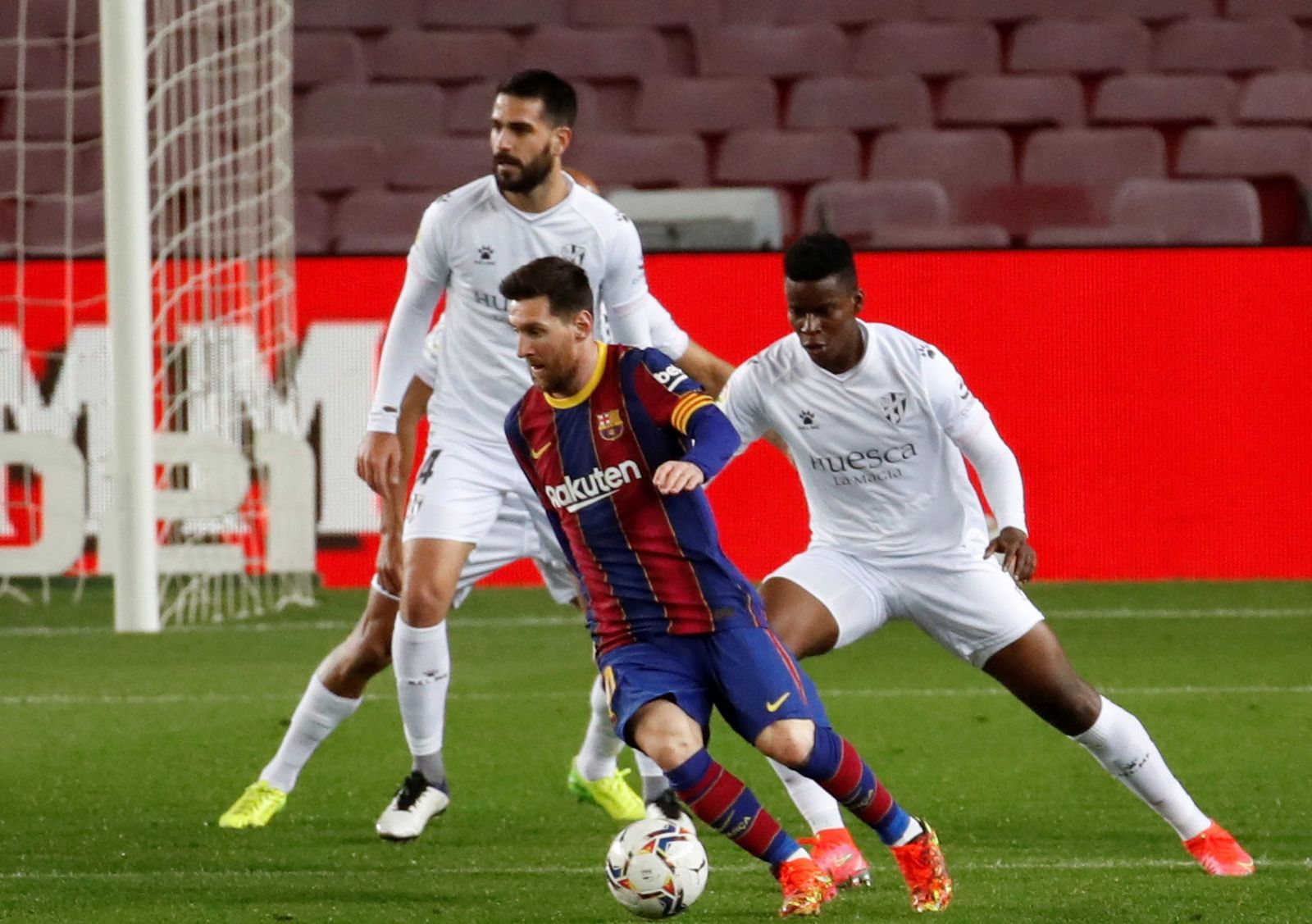epa09077087 FC Barcelona's striker Leo Messi (C) vies for the ball with Huesca's midfielder Idrissa Doumbia (R)  during the Spanish LaLiga soccer match between FC Barcelona and SD Huesca held in Barcelona, Catalonia, Spain, 15 March 2021.  EPA/Toni Albir