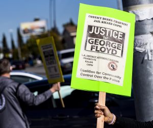 epa09084816 A demonstrator holds a poster during a protest organized by the members of the 'Coalition for Community Control Over the Police' to demand a conviction in the Minnesota trial of former Officer Derek Chauvin for the death of George Floyd and calling on District Attorney George Gascon to prosecute 'killer cops' in Los Angeles, California, USA, 19 March 2021.  EPA/ETIENNE LAURENT