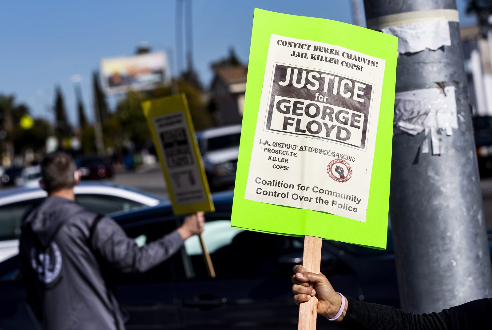 epa09084816 A demonstrator holds a poster during a protest organized by the members of the 'Coalition for Community Control Over the Police' to demand a conviction in the Minnesota trial of former Officer Derek Chauvin for the death of George Floyd and calling on District Attorney George Gascon to prosecute 'killer cops' in Los Angeles, California, USA, 19 March 2021.  EPA/ETIENNE LAURENT