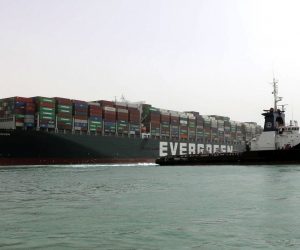 epa09095734 A handout photo made available by the Suez Canal Authority, shows the Ever Given container ship (L) in the Suez Canal, Egypt, 25 March 2021. the Ever Given, a large container ship ran aground in the Suez Canal on 23 March, blocking passage of other ships and causing a traffic jam for cargo vessels.  The head of the Suez Canal Authority announced on 25 March that "the navigation through the Suez Canal is temporarily suspended" until the floatation of the Ever Given is completed. Its floatation is being carried out by 8 large tugboats that are towing and pushing the grounding vessel.  EPA/SUEZ CANAL AUTHORITY/HO EDITORIAL USE ONLY NO SALES HANDOUT EDITORIAL USE ONLY/NO SALES