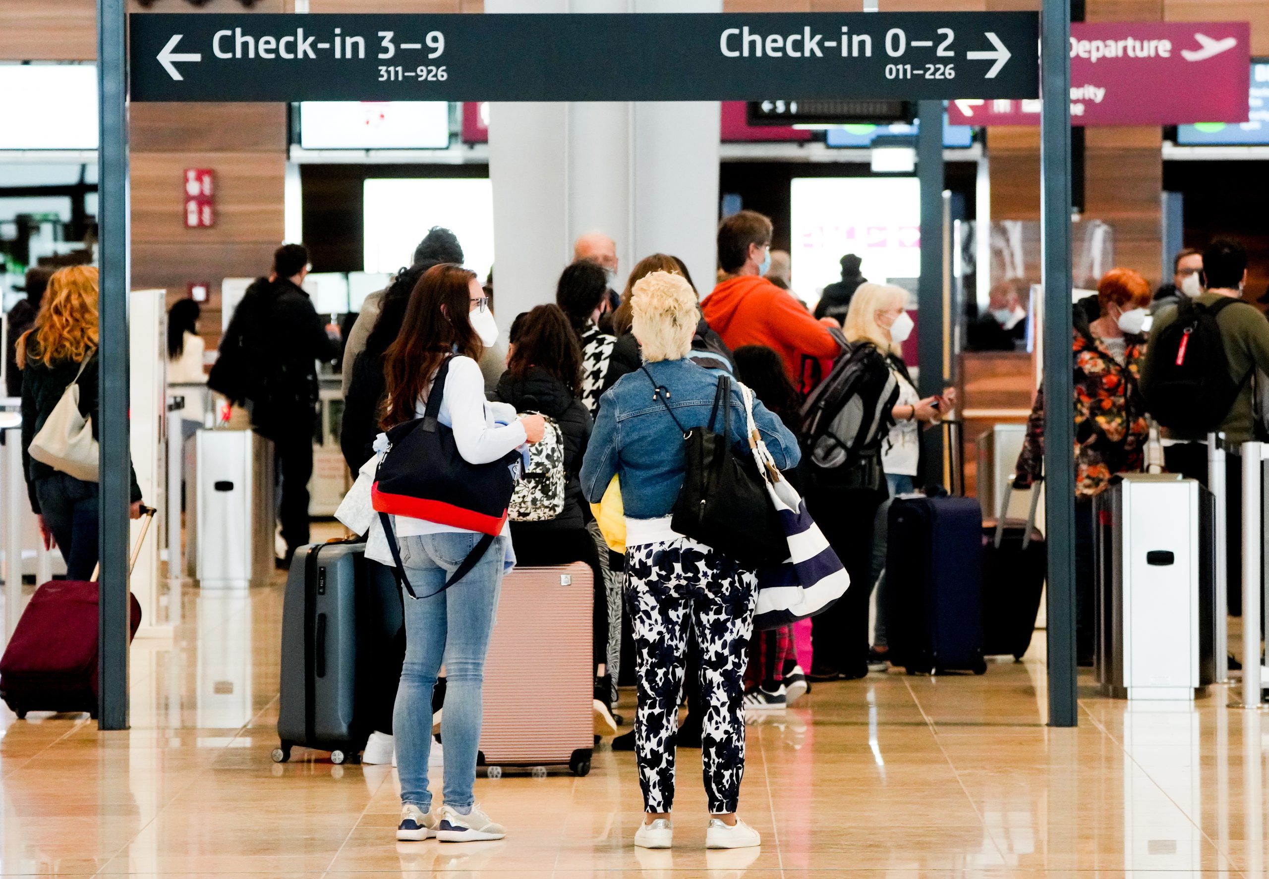 epa09098353 Passengers wait in line to check-in for their flight at Terminal 1 of the Berlin Brandenburg Airport, in Schoenefeld, Germany, 26 March 2021. German tourist are set to travel to the Spanish island of Mallorca over the Easter holiday season after popular tourist destination was taken off Germany’s list of coronavirus 'risk areas.'  EPA/FILIP SINGER