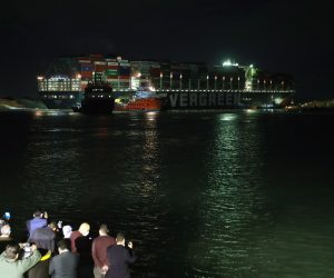 epaselect epa09101957 The Ever Given container ship which ran aground in the Suez Canal, Egypt, 27 March 2021. The Ever Given, a large container ship ran aground in the Suez Canal on 23 March, blocking passage of other ships and causing a traffic jam for cargo vessels. The head of the Suez Canal Authority announced that 'the navigation through the Suez Canal is temporarily suspended' until the floatation of the Ever Given is completed. Its floatation is being carried out by eight large tugboats that are towing and pushing the grounding vessel  EPA/KHALED ELFIQI