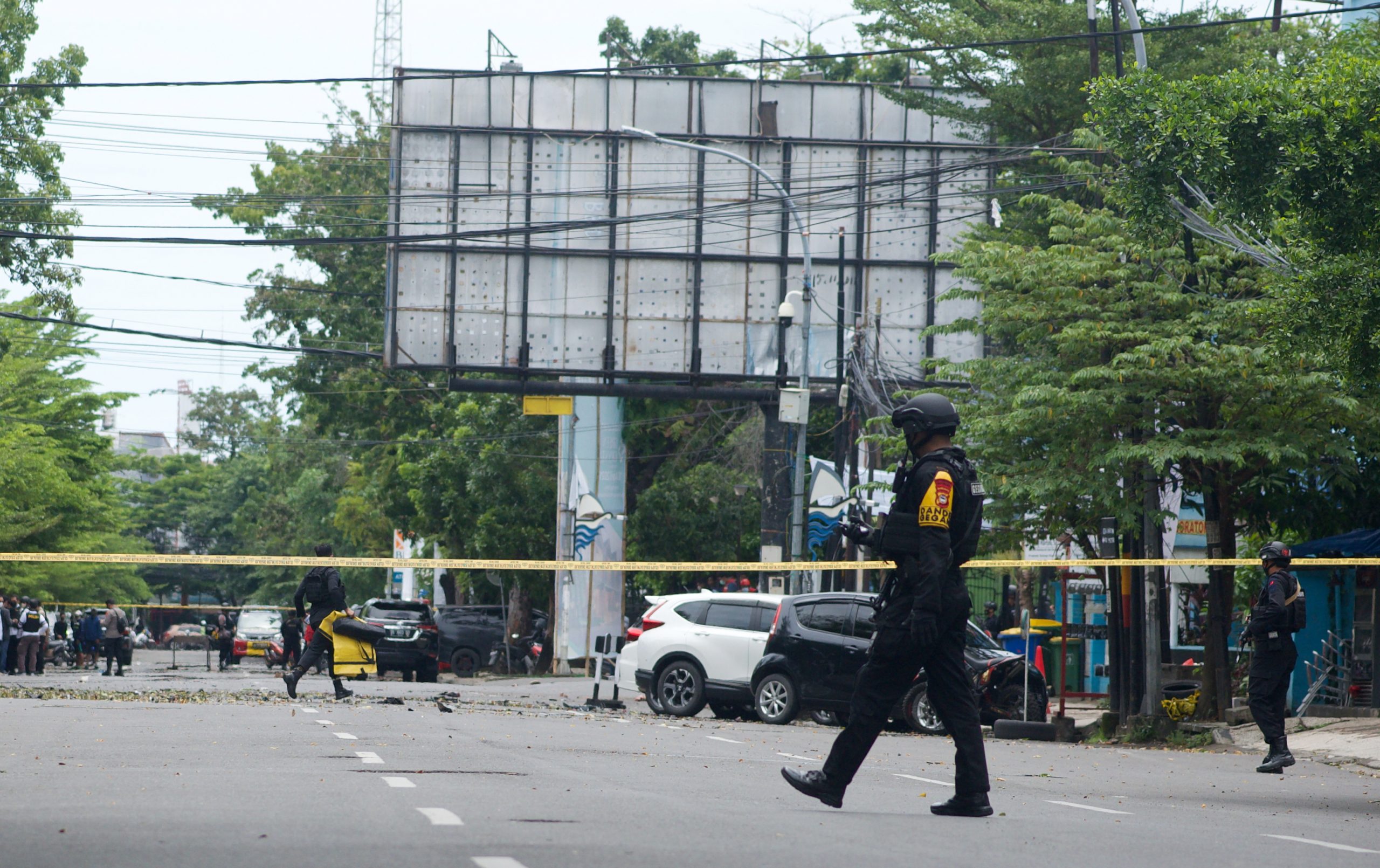 epa09102556 Police counter-terrorism squad members cordon off the area surrounding the Sacred Heart of Jesus Cathedral in the aftermath of an explosion, in Makassar, South Sulawesi, Indonesia, 28 March 2021. At least nine people were wounded as a suspected suicide bomber blew themselves up outside the church on Palm Sunday. The number of casualties was still unclear.  EPA/IQBAL LUBIS
