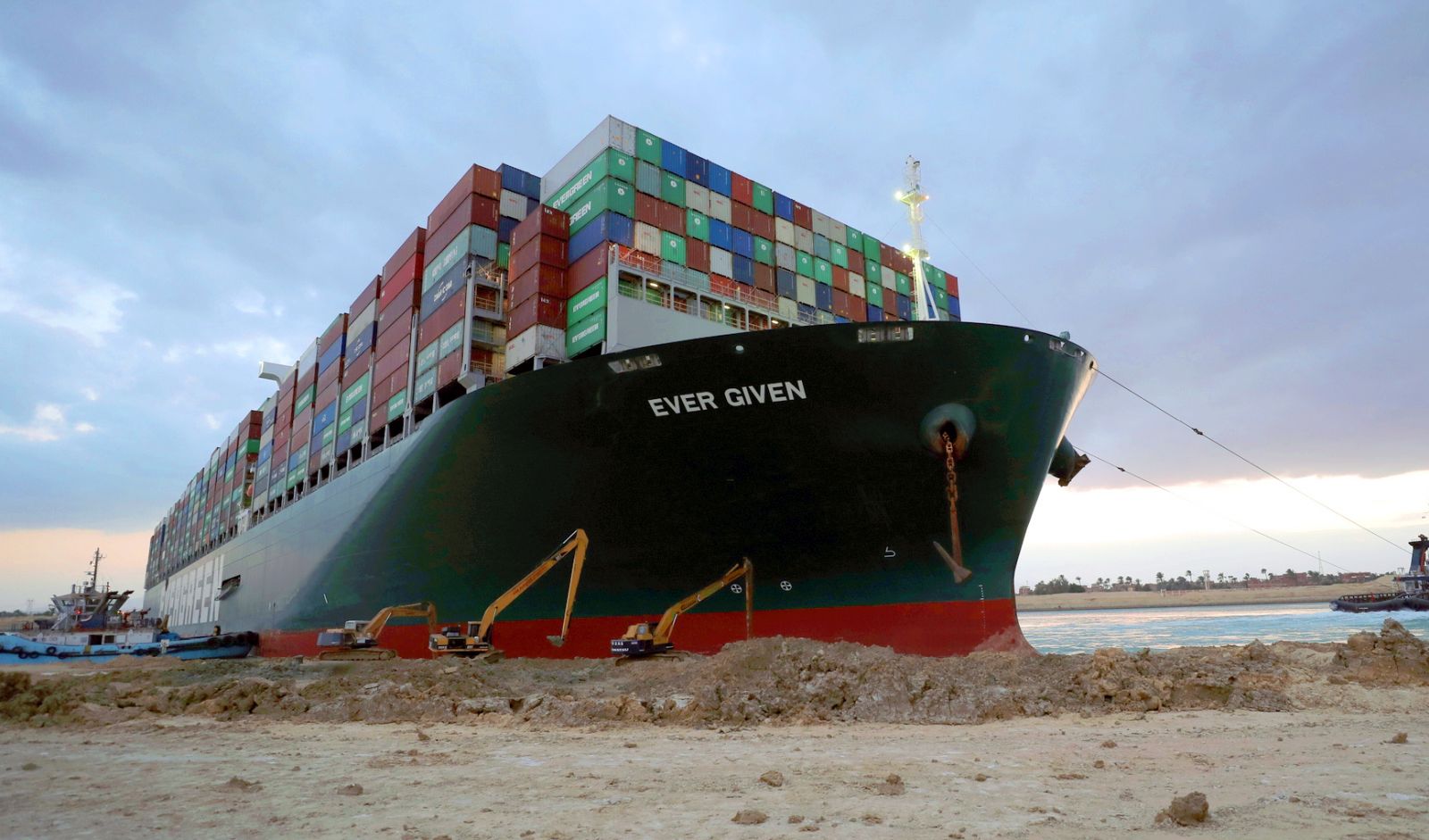 epa09103013 A handout photograph made available by the Suez Canal Authority, shows floatation work being carried out on the Ever Given container ship which ran aground in the Suez Canal, Egypt, 28 March 2021. The Ever Given, a large container ship ran aground in the Suez Canal on 23 March, blocking passage of other ships and causing a traffic jam for cargo vessels. The head of the Suez Canal Authority announced  on 28 March that efforts for the floatation of the Ever Given are continuing. Its floatation is being carried out by 14 tugboats that are towing and pushing the grounding vessel, it has on 27 March moved by two inches and the authorities hope that the ship will move further after the water starts running underneath it.  EPA/SUEZ CANAL AUTHORITY /HO HANDOUT   EDITORIAL USE ONLY NO SALES HANDOUT EDITORIAL USE ONLY/NO SALES