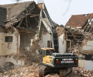 11.03.2021., Petrinja, vedar i  suncan dan u razrusenom Petrinji, gradjevinski strojevi u centru ruse objekt starog hotela koji se nalazio u neposrednoj blizini nekadasnjeg trgovackog centra Petrinjke. Sablasno prazne ulice grada s pokojim prolaznikom govori o odlasku stanovnika iz ovog starog Hrvatskog grada.
Photo: Robert Anic/PIXSELL
