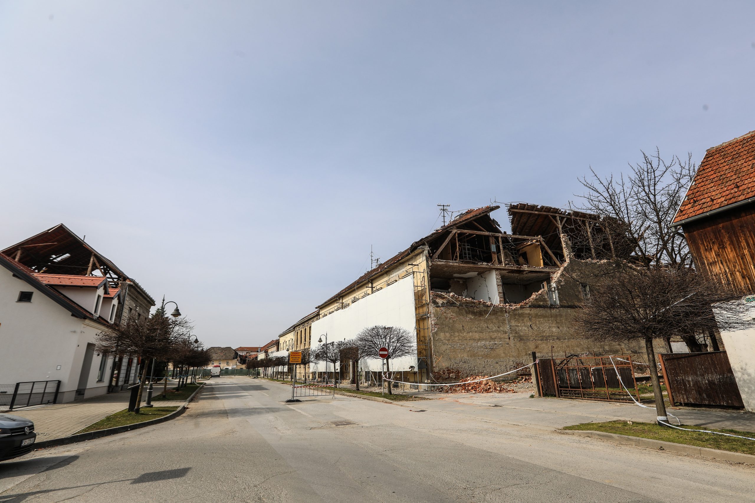 11.03.2021., Petrinja, vedar i  suncan dan u razrusenom Petrinji, gradjevinski strojevi u centru ruse objekt starog hotela koji se nalazio u neposrednoj blizini nekadasnjeg trgovackog centra Petrinjke. Sablasno prazne ulice grada s pokojim prolaznikom govori o odlasku stanovnika iz ovog starog Hrvatskog grada.
Photo: Robert Anic/PIXSELL