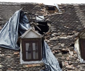 17.03.2021.,Sisak - Jak vjetar "igra"se sa plasticnim folijama kojima su prekrivena ostecenja na krovovima kuca nastalim u prosinackom potresu.
Photo: Nikola Cutuk/PIXSELL