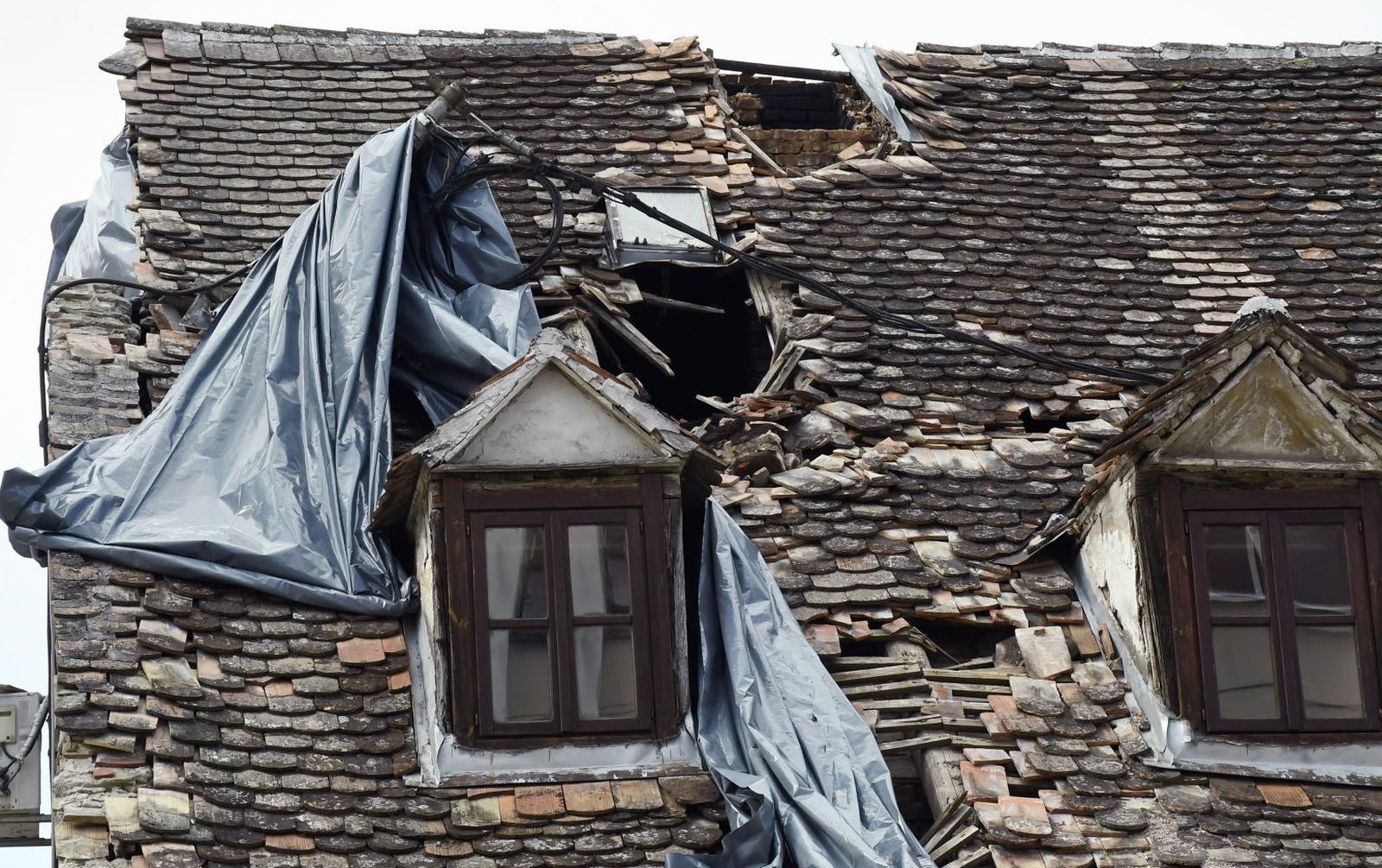 17.03.2021.,Sisak - Jak vjetar "igra"se sa plasticnim folijama kojima su prekrivena ostecenja na krovovima kuca nastalim u prosinackom potresu.
Photo: Nikola Cutuk/PIXSELL