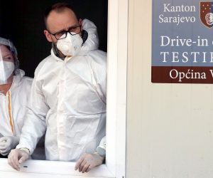 epa09083941 Health workers wait at drive-through COVID-19 testing center at a car park in Sarajevo, Bosnia and Herzegovina, 19 March 2021. Bosnian authorities announced lockdown measures, including nighttime curfew and closure of restaurants, after a spike in coronavirus infections in the capital. Over the past two weeks, Sarajevo recorded over 1,700 new infections and high coronavirus-related death rate of 31.5 per 100,000 inhabitants, the highest in Western Balkans. The nation with over a three million people is yet to launch a vaccination campaign for its citizens.  EPA/FEHIM DEMIR