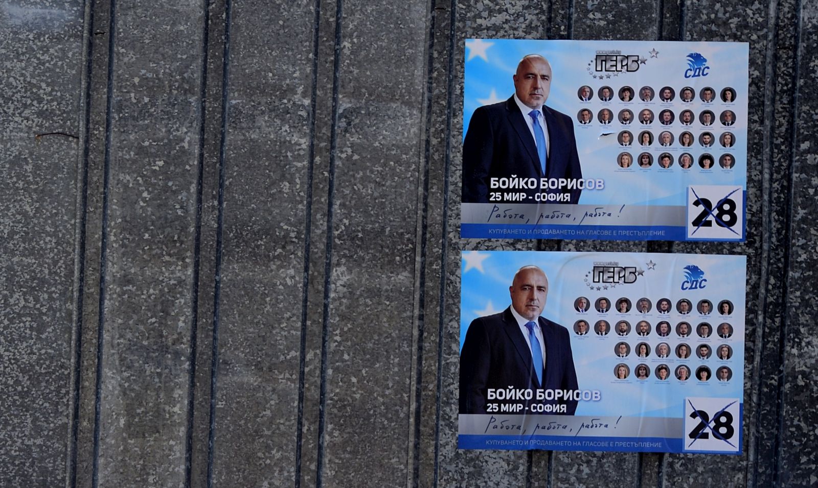 epa09108200 A man with a bicycle passes in front of campaign posters of Bulgaria's centre-right ruling GERB party with pictures of Bulgarian Prime minister Boyko Borissov in Bankaj, Bulgaria, 31 March 2021. Bulgaria will hold parliamentary elections on 04 April 2021.  EPA/VASSIL DONEV