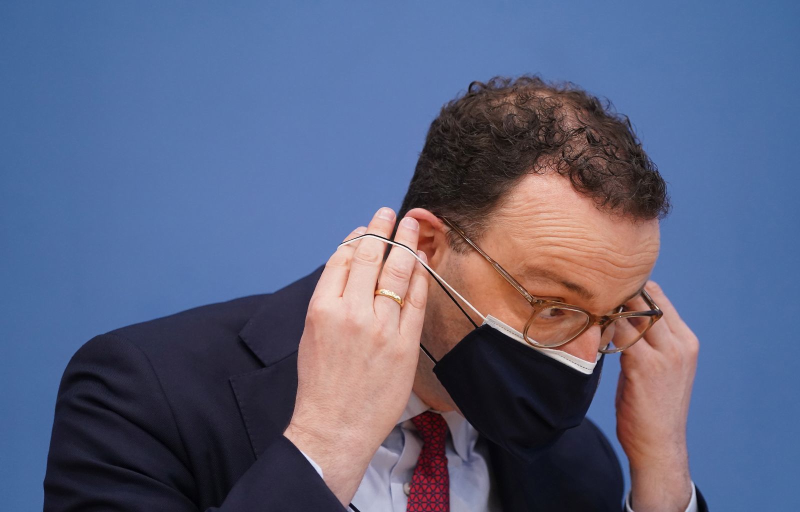 epa09110089 German Health Minister Jens Spahn removes his mask as he arrives to speak to the media to outline the large-scale rollout of inoculations against Covid-19 at private medical practices during the third wave of the coronavirus pandemic in Berlin, Germany, 01 April 2021. The rollout is to begin next week nationwide and will come as a further means for increasing the pace of vaccinations.  EPA/Sean Gallup / POOL