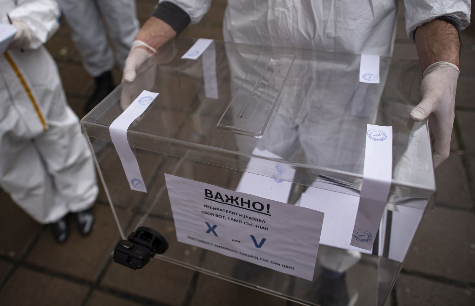 epa09114919 A staff member of a mobile polling station wearing a protective suits holds a mobile ballot box at Pirogov Hospital in Sofia, Bulgaria, 04 April 2021. Bulgaria is holding a parliamentary election on 04 April amid a surge in coronavirus COVID-19 cases. Despite criticisms, the GERB party led by incumbent Prime Minister Boyko Borissov is leading the polls and is expected to win another four-year term.  EPA/VASSIL DONEV