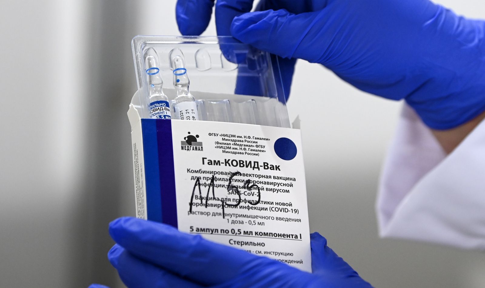 epa09120594 A nurse takes out vials of the Russian Sputnik V vaccine against Covid-19 during vaccination at the Arena 'Boris Trajkovski' in Skopje, North Macedonia, 05 April 2021 (reissued 07 April 2021). The prime minister of the German federal state Bavaria Soeder on 07 April 2021 said the state had signed a preliminary contract over a purchase of Russian COVID-19 vaccine Sputnik V. An approval for the vaccine by the European Medicines Agency (EMA) is pending.  EPA/GEORGI LICOVSKI *** Local Caption *** 56807518