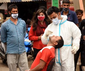 epa09146714 A health worker takes a nasal swab sample of a man to test for COVID-19 at a wholesale market in Jammu, the winter capital of Kashmir, India, 20 April 2021. India is seeing a second wave of the virus which has led several states including Maharashtra and the capital, New Delhi and Madhya Pradesh to impose new restrictions.  EPA/JAIPAL SINGH