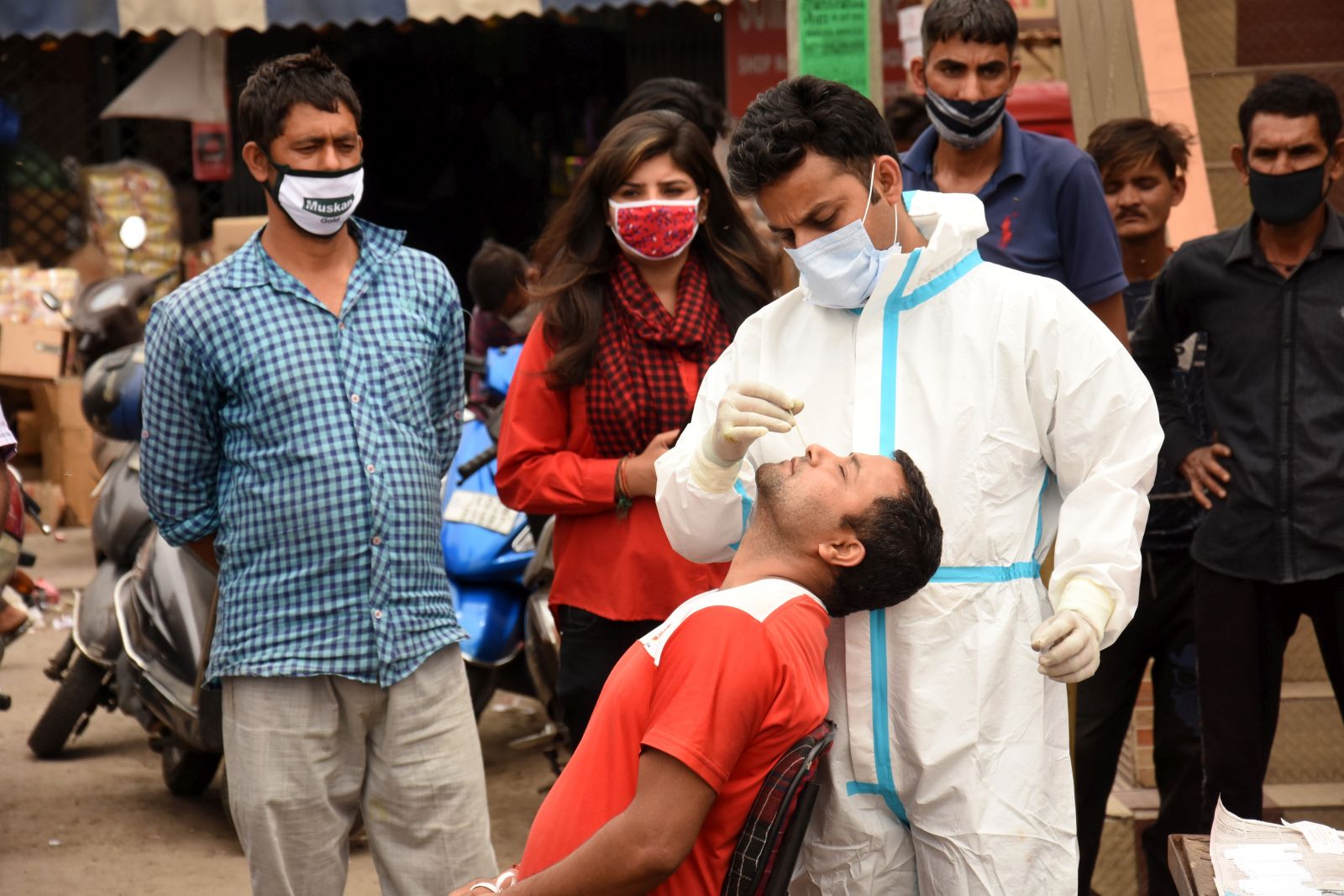 epa09146714 A health worker takes a nasal swab sample of a man to test for COVID-19 at a wholesale market in Jammu, the winter capital of Kashmir, India, 20 April 2021. India is seeing a second wave of the virus which has led several states including Maharashtra and the capital, New Delhi and Madhya Pradesh to impose new restrictions.  EPA/JAIPAL SINGH