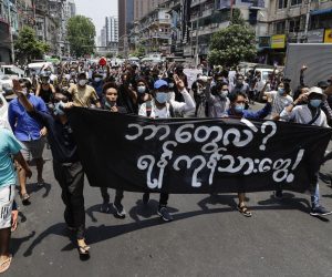 epa09154147 Demonstrators hold a banner that reads 'What is this? We are Yangon people', as they march during a protest against the military coup in downtown Yangon, Myanmar, 23 April 2021. According to the United Nations, nearly 3.5 million people in Myanmar may struggle to afford food in the coming months in the wake of the military coup and financial crisis.  EPA/STRINGER
