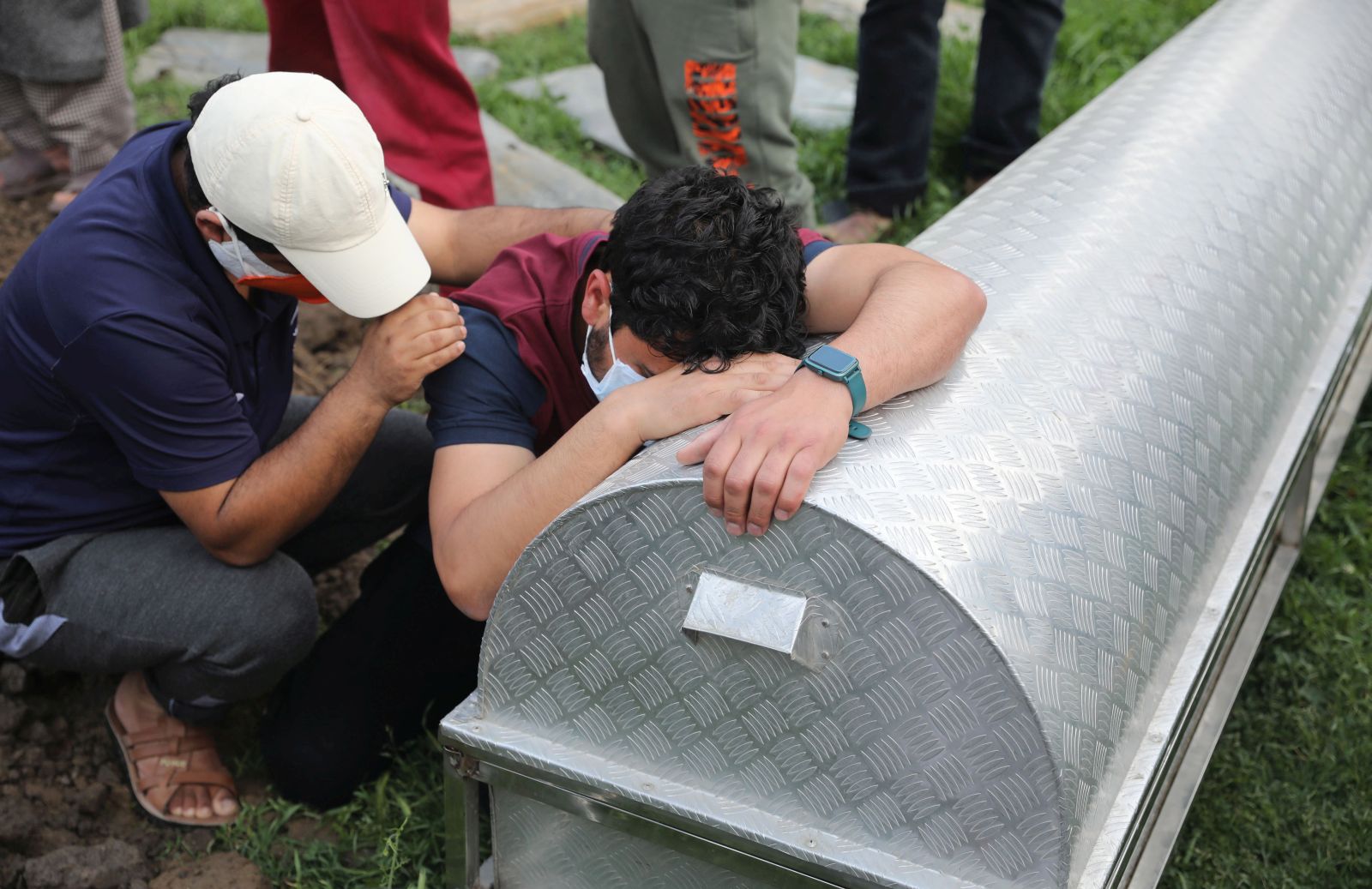 epaselect epa09180934 Kashmiri people mourn at the coffin of their relative who died of Covid-19 coronavirus, before his burial at a graveyard on the outskirts of Srinagar, the summer capital of Indian Kashmir, 06 May 2021. Officials announced on 06 May that the Coronavirus death toll has now reached 2539 after 29 COVID19 patients lost their lives on 05 May. In view of the rising COVID-19 cases and to contain its spread, the government extended the curfew till 10 May 2021 in four districts of Jammu and Kashmir including Srinagar and Jammu.  EPA/FAROOQ KHAN