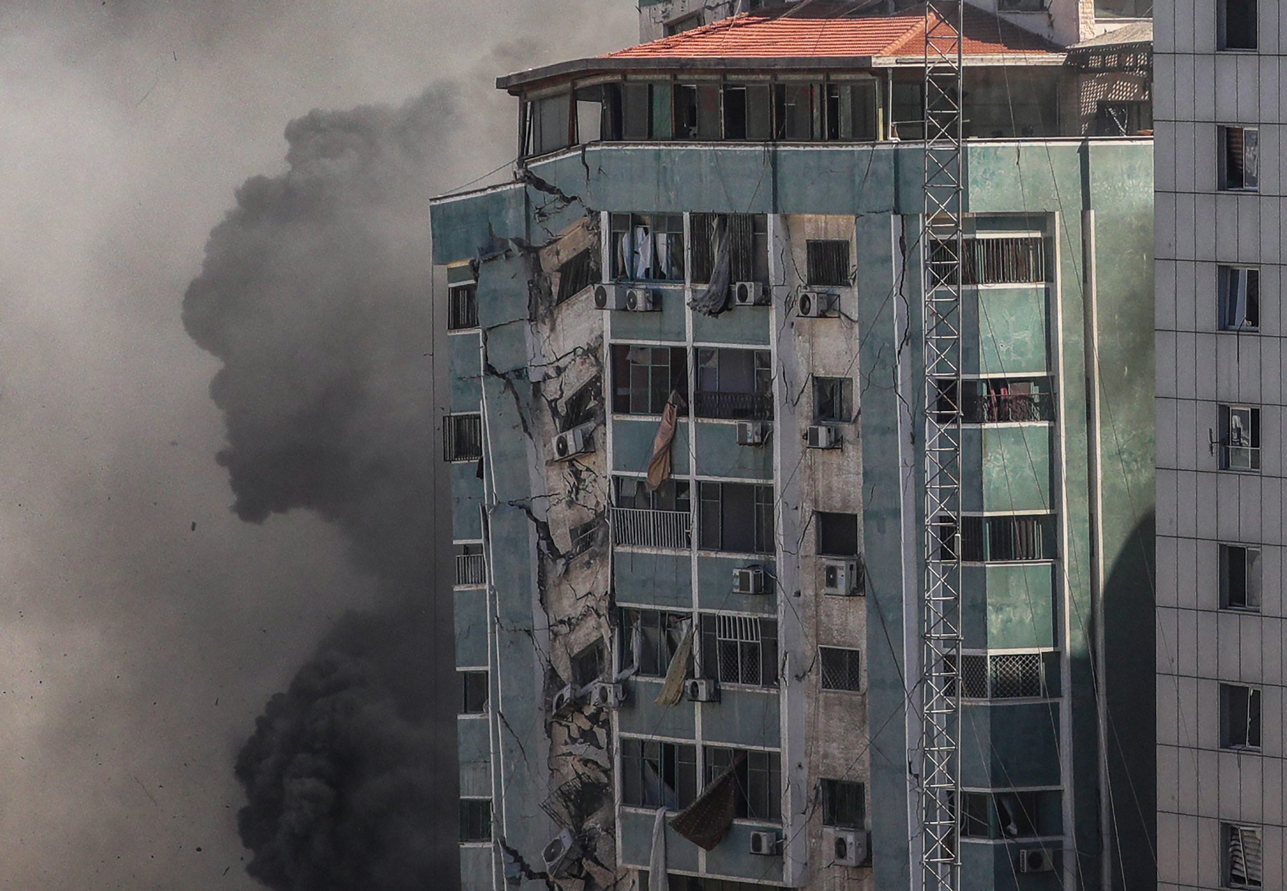 epa09201670 Smoke rises after an Israeli airstrike hits Al-Jalaa tower, which houses apartments and several media outlets, including The Associated Press and Al Jazeera, in Gaza City, 15 May 2021. In response to days of violent confrontations between Israeli security forces and Palestinians in Jerusalem, various Palestinian militants factions in Gaza launched rocket attacks since 10 May that killed at least nine Israelis to date. According to the Palestinian Ministry of Health, at least 139 Palestinians, including 39 children, were killed in the recent retaliatory Israeli airstrikes.  EPA/MOHAMMED SABER