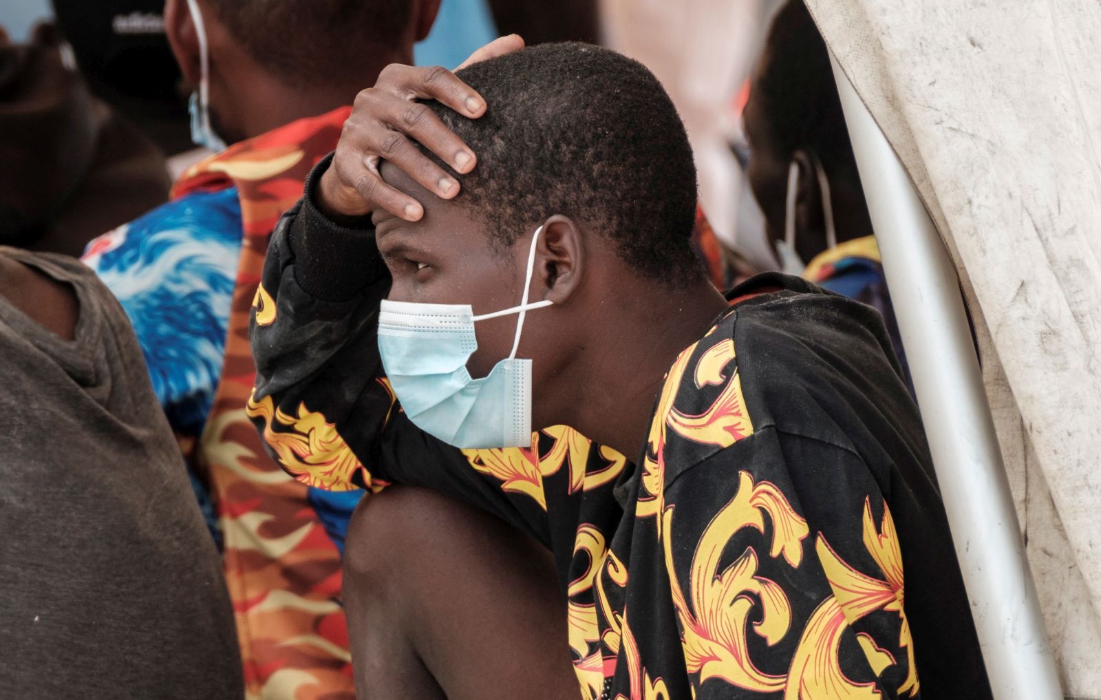 epa09205624 Migrants are seen upon arrival to Arguineguin port, in Gran Canaria, Canary islands, Spain, 16 May 2021. Spanish Salvamento Maritimo's boat 'Talia' rescued 55 sub-Saharan migrants, 54 men, and a woman, as they traveled on a dugout 100 km away from the island.  EPA/ANGEL MEDINA G.